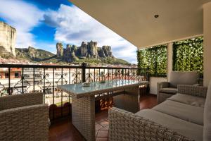 a balcony with a table with a view of the mountains at Meteora View Penthouse in Kalabaka