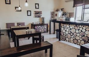a restaurant with tables and a kitchen with a counter at Roof Top Hostel in Tirana