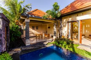 a villa with a swimming pool in front of a house at Asri Sari Villa Ubud in Ubud