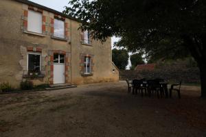 a table and chairs in front of a building at La Chaussée de l'Etang in Marcenay