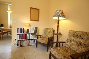 a living room with a chair and a lamp and a book shelf at La Chaussée de l'Etang in Marcenay