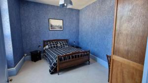 a bedroom with blue walls with a bed in it at La Chaussée de l'Etang in Marcenay