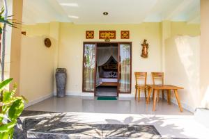 a room with a table and chairs and a door at Asri Sari Villa Ubud in Ubud