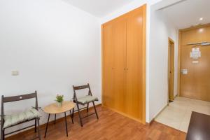 a room with two chairs and a table and a door at GuestReady - Domocenter studio with garage in Bormujos +36 photos