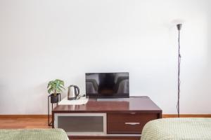 a living room with a tv on a wooden table at GuestReady - Domocenter studio with garage in Bormujos