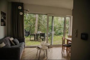 a living room with a couch and a table at Sam Las Apartamenty Białowieża in Białowieża