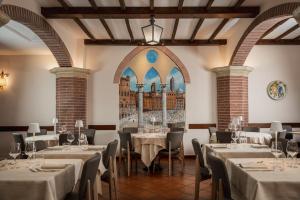 a dining room with tables and chairs and a window at Hotel Athena in Siena