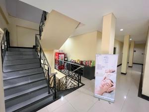 a staircase in a building with a sign next to it at Tentrem BS Residence in Semarang