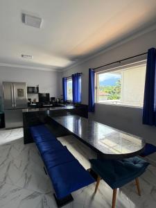 a dining room with a glass table and blue chairs at Villa's Boraceia in Boracéia