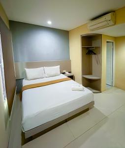 a bedroom with a large white bed in a room at Tentrem BS Residence in Semarang +20 photos