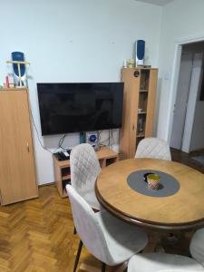 a living room with a table and chairs and a television at Apartman Vuković, Majdanpek in Majdanpek +51 photos