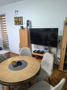 a room with a table and chairs and a television at Apartman Vuković, Majdanpek in Majdanpek