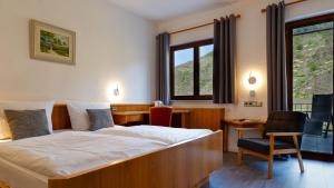 a bedroom with a bed and a desk and a chair at Hotel Kachelburg in Dieblich