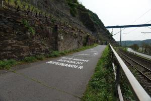 a road with white writing on it next to a brick wall at Hotel Kachelburg in Dieblich +4 photos