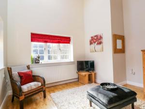 a living room with a chair and a tv at The Barn at Myrtle Cottage in Marlborough