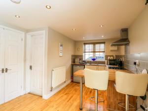 a kitchen with a table and chairs in a room at The Barn at Myrtle Cottage in Marlborough