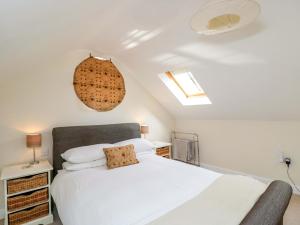 a bedroom with a large white bed and a skylight at The Barn at Myrtle Cottage in Marlborough