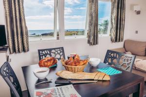 a table with a basket of bread on it with windows at Camping La Pointe du Talud in Ploemeur