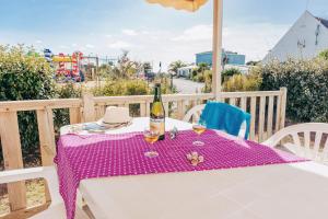 a table with a bottle of wine and a hat at Camping La Pointe du Talud in Ploemeur