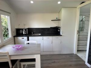 a kitchen with white cabinets and a wooden table at La Casita del Escorial -Nueva reforma Tranquilidad y jardín privado in El Escorial