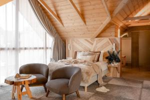 a bedroom with a bed and two chairs at Nova Hill in Zakopane