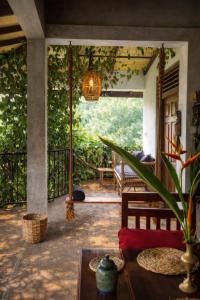 a porch of a house with a table and a swing at Tantra Ella Lodge in Ella
