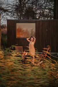 a woman in a dress standing in front of a building at Houseboat Pałuki in Sobiejuchy