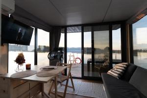 a living room with a couch and a table with a television at Houseboat Pałuki in Sobiejuchy