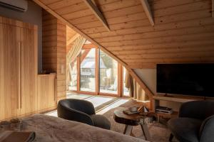 a living room with a tv and a large window at Nova Hill in Zakopane
