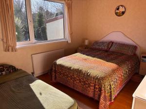 a small bedroom with two beds and a window at The Wild Atlantic Hideaway in Inch