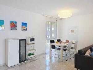 a white living room with a table and chairs at Apartment Apt- Hermosa by Interhome in Locarno