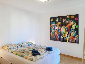 a bed in a room with a painting on the wall at Apartment Apt- Hermosa by Interhome in Locarno