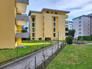 a yellow building with a fence in front of it at Apartment Apt- Hermosa by Interhome in Locarno