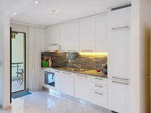 a white kitchen with white cabinets and a sink at Apartment Apt- Hermosa by Interhome in Locarno