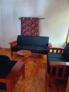 a living room with a blue couch and a table at Ndege Cottage in Mai Mahoro