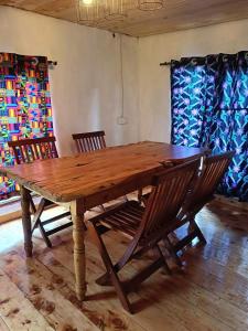 a wooden table with two chairs sitting around it at Ndege Cottage in Mai Mahoro