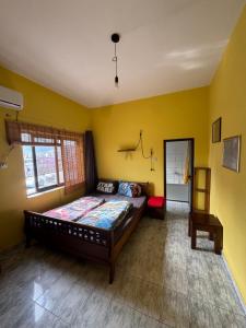 a bedroom with a bed in a room with yellow walls at Roof Top Hostel in Tirana
