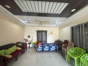 a living room with a bed and chairs and a ceiling at Hotel Moturi Farmstay Vemulawada in Vemalwāda +12 photos