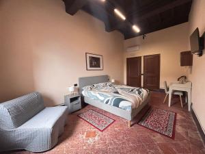 a bedroom with a bed and a couch and a table at Barberini Guest House Palestrina in Palestrina