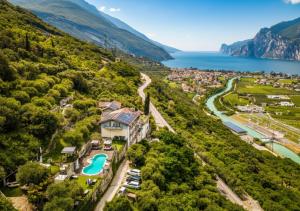 an aerial view of a house on a hill next to a lake at Hotel Isola Verde in Nago-Torbole