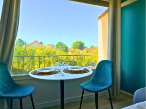 a table and chairs on a balcony with a view at Le Pic'Vert - Escapade Solo ou Duo - Hôpital à 400m - Parking gratuit - GARE & CENTRE HISTORIQUE 15min à pied - Clim - Balcon au calme in Bergerac