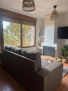 a living room with a couch and a fireplace at Atempo Berzosa Arce in Berzosa del Lozoya