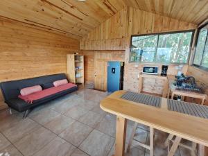 a room with a couch and a table in a cabin at Cabaña Ardilla Corralillo in Corralillo