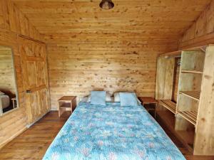 a bedroom with a bed in a wooden room at Cabaña Ardilla Corralillo in Corralillo