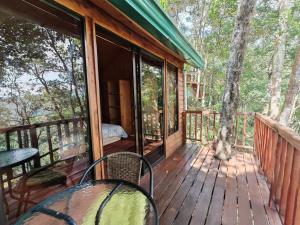 a porch of a cabin with a table and chairs at Cabaña Ardilla Corralillo in Corralillo