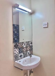 a bathroom with a sink and a mirror at COZY Two BEDROOM in Bamburi +9 photos