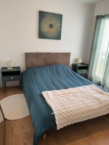a bedroom with a bed with a blue comforter at Les Trinitaires in Sarzeau