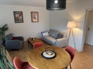 a living room with a table and a couch at Les Trinitaires in Sarzeau +14 photos