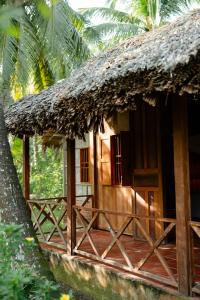 a small hut with a thatch roof and a porch at Le Mékong Vert Ecolodge in Ben Tre +6 photos