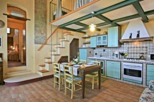 a kitchen with blue cabinets and a table and chairs at Casalecchi - Cottage between Siena & Florence in Poggibonsi